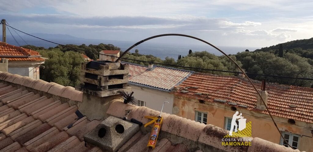 Souche de cheminée et câbles d'antenne sur les toits de tuiles d'un village