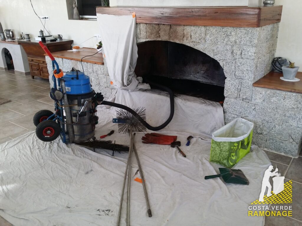 Salon entièrement bâché, aspirateur et cannes de ramonage posés au sol avant le ramonage de la cheminée