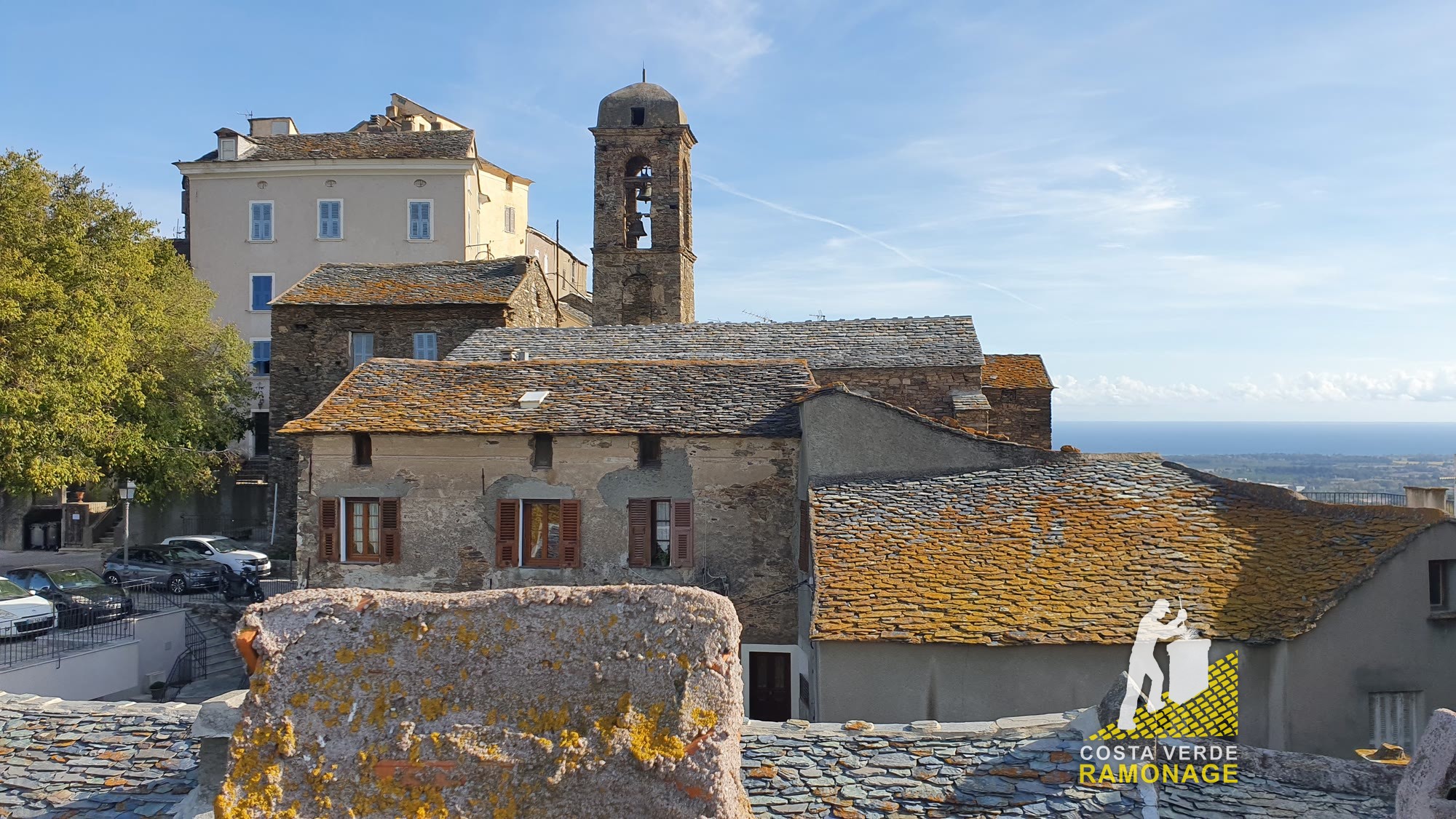 Toits de pierre et clocher d'un village de la côte orientale de la Haute-Corse, vus depuis une toiture