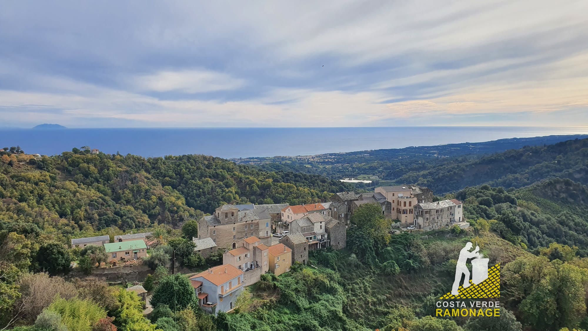 Village accroché à la colline, la plaine orientale et la mer au loin